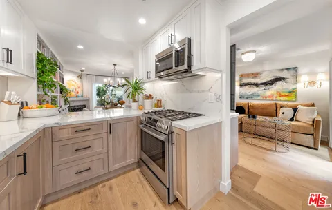 a kitchen with white cabinets and appliances