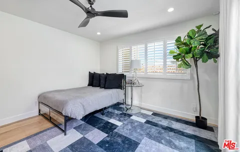 a bedroom with a bed window and a potted plant