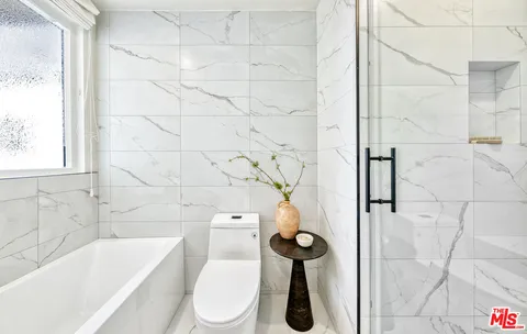 a spacious bedroom with a bed and a large window