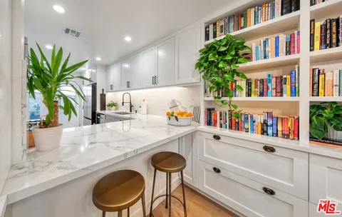 a kitchen with a refrigerator and a white wooden cabinets