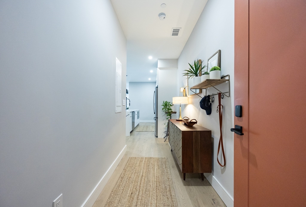 70 Shawsheen Road, Unit PH5 Boston, MA 02128 - Photo 35 of 42 a view of a hallway with a dining table & chairs