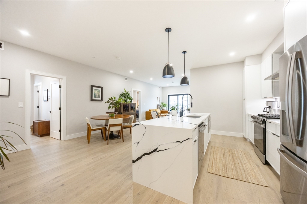 70 Shawsheen Road, Unit PH5 Boston, MA 02128 - Photo 4 of 42 a living room with stainless steel appliances kitchen island granite countertop furniture and a wooden floor