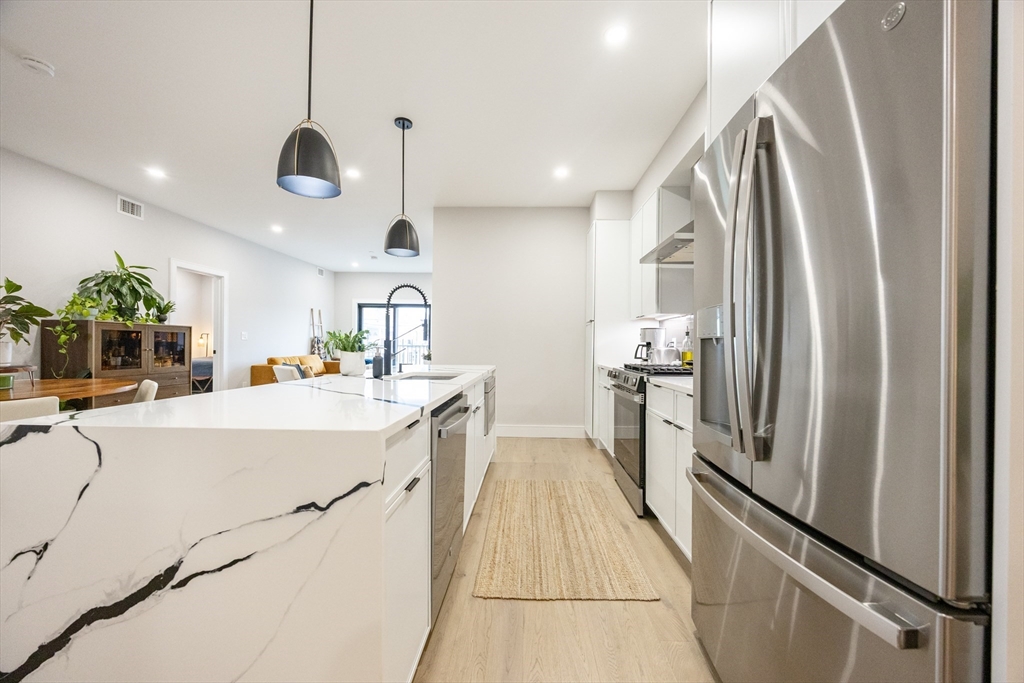 70 Shawsheen Road, Unit PH5 Boston, MA 02128 - Photo 5 of 42 a large kitchen with a large counter top appliances and cabinets
