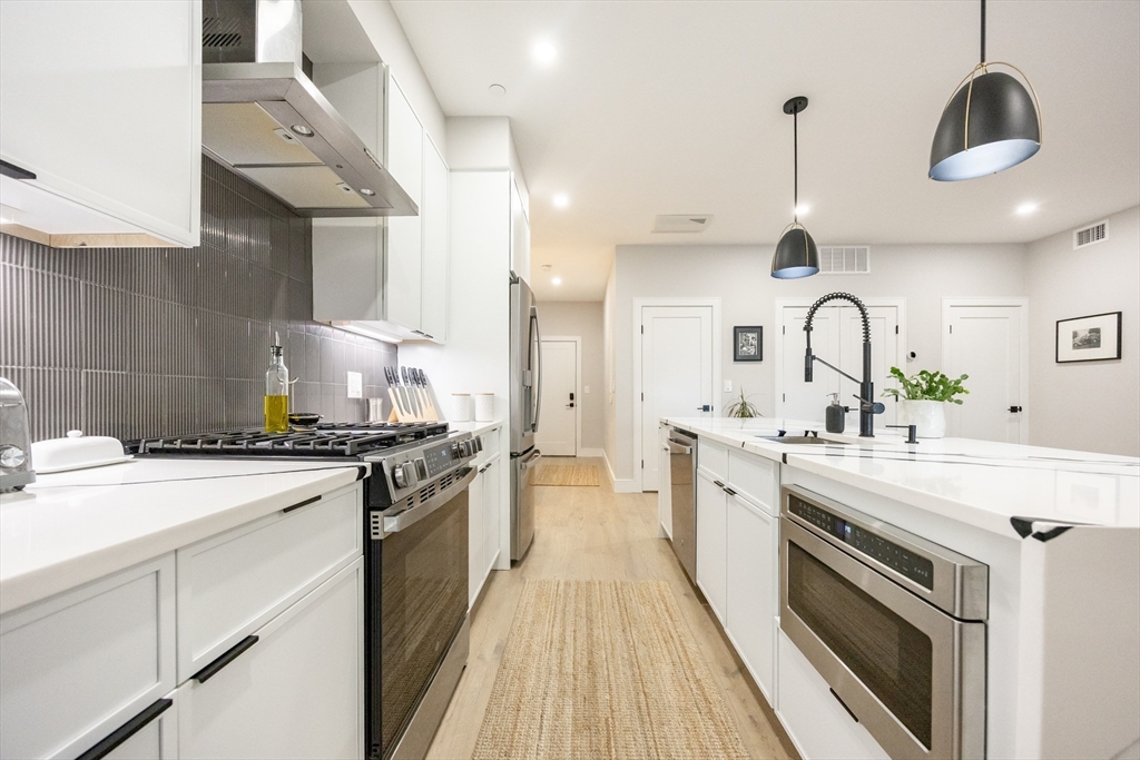70 Shawsheen Road, Unit PH5 Boston, MA 02128 - Photo 6 of 42 a large kitchen with stainless steel appliances granite countertop a stove and a sink