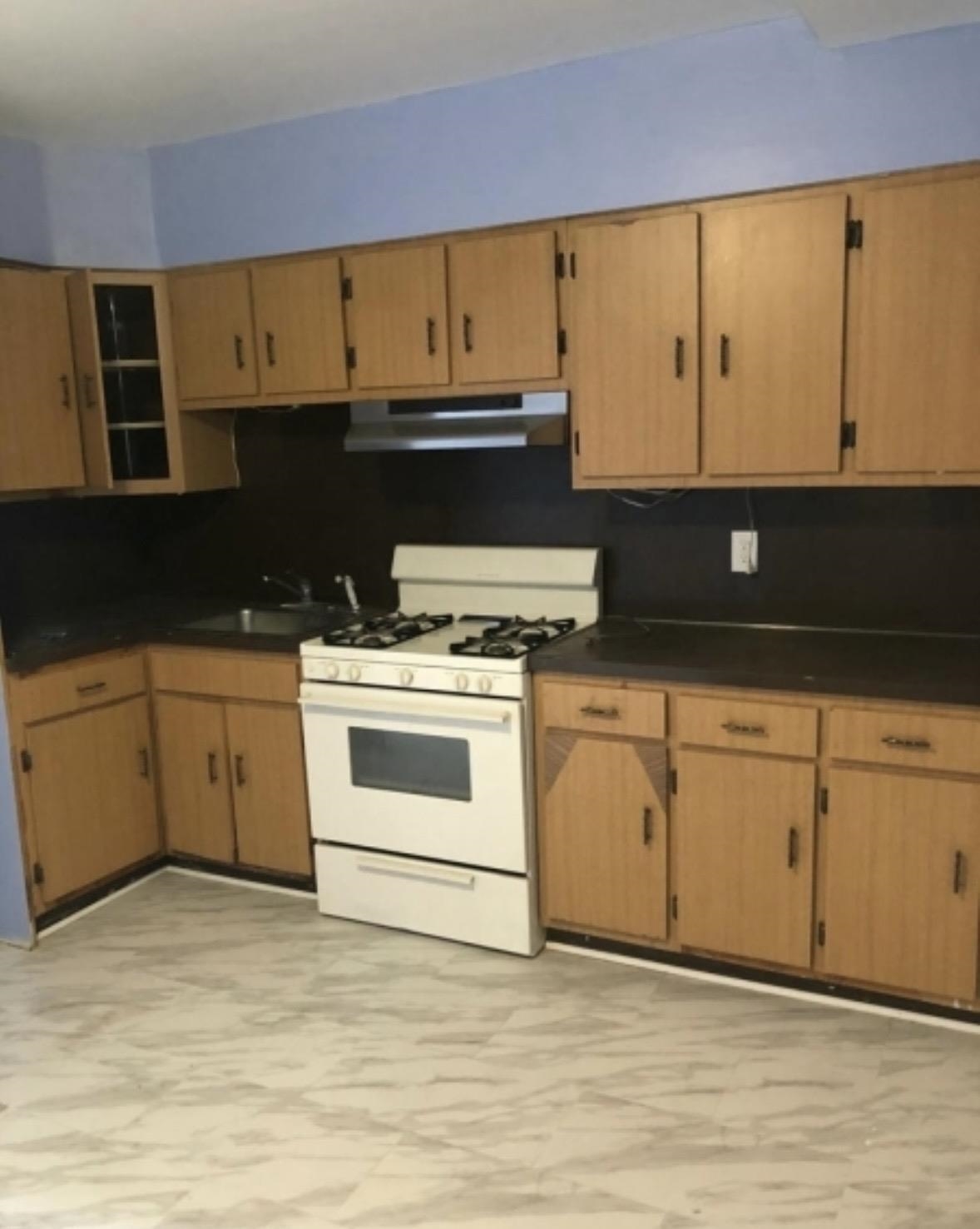 505 5th Street Union City, NJ 07087 - Photo 3 of 17 a kitchen with a stove cabinets and wooden floor