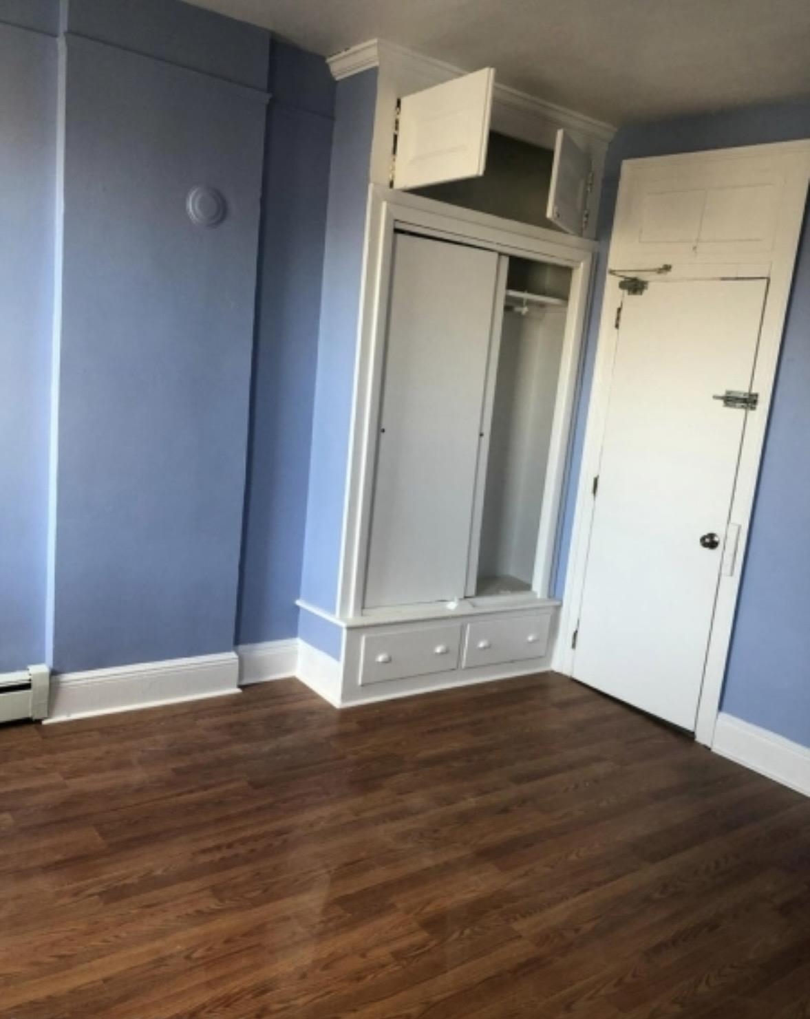 505 5th Street Union City, NJ 07087 - Photo 8 of 17 an empty room with wooden floor and mirror