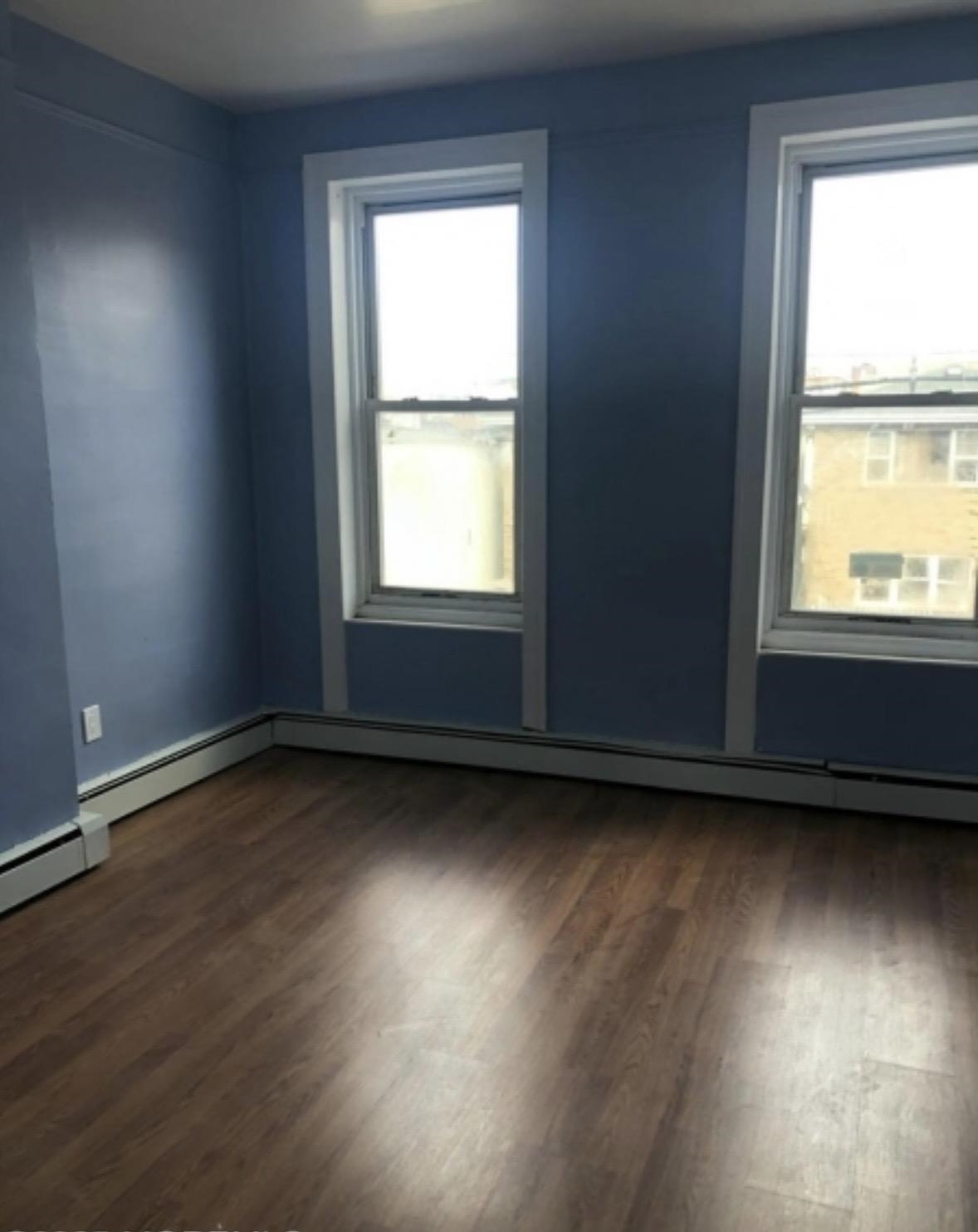 505 5th Street Union City, NJ 07087 - Photo 9 of 17 an empty room with wooden floor and windows