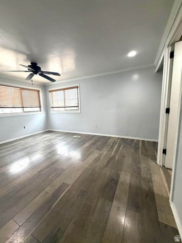 2491 Highway 89, Unit 114 Pleasant View, UT 84404 - Photo 7 of 18 Empty room featuring dark wood-type flooring, ceiling fan, and crown molding