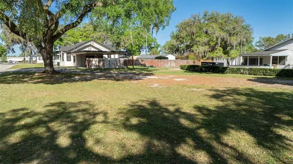 a front view of a house with a yard and trees
