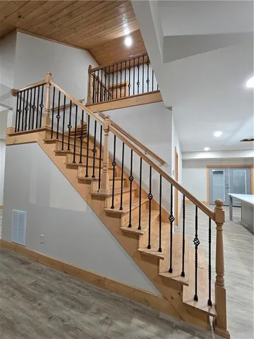 a view of staircase with lots of frames on wall and wooden floor