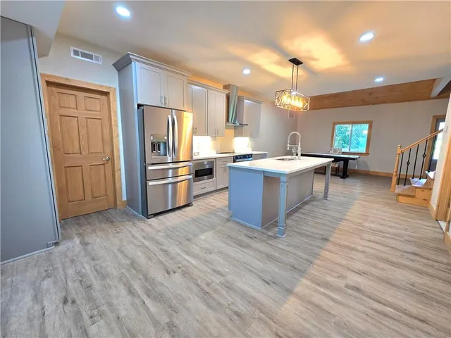 a view of kitchen with sink microwave and refrigerator