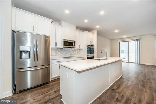 a kitchen with stainless steel appliances kitchen island granite countertop a stove and a refrigerator