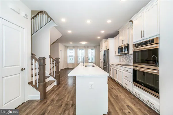 a kitchen with a sink and steel appliances
