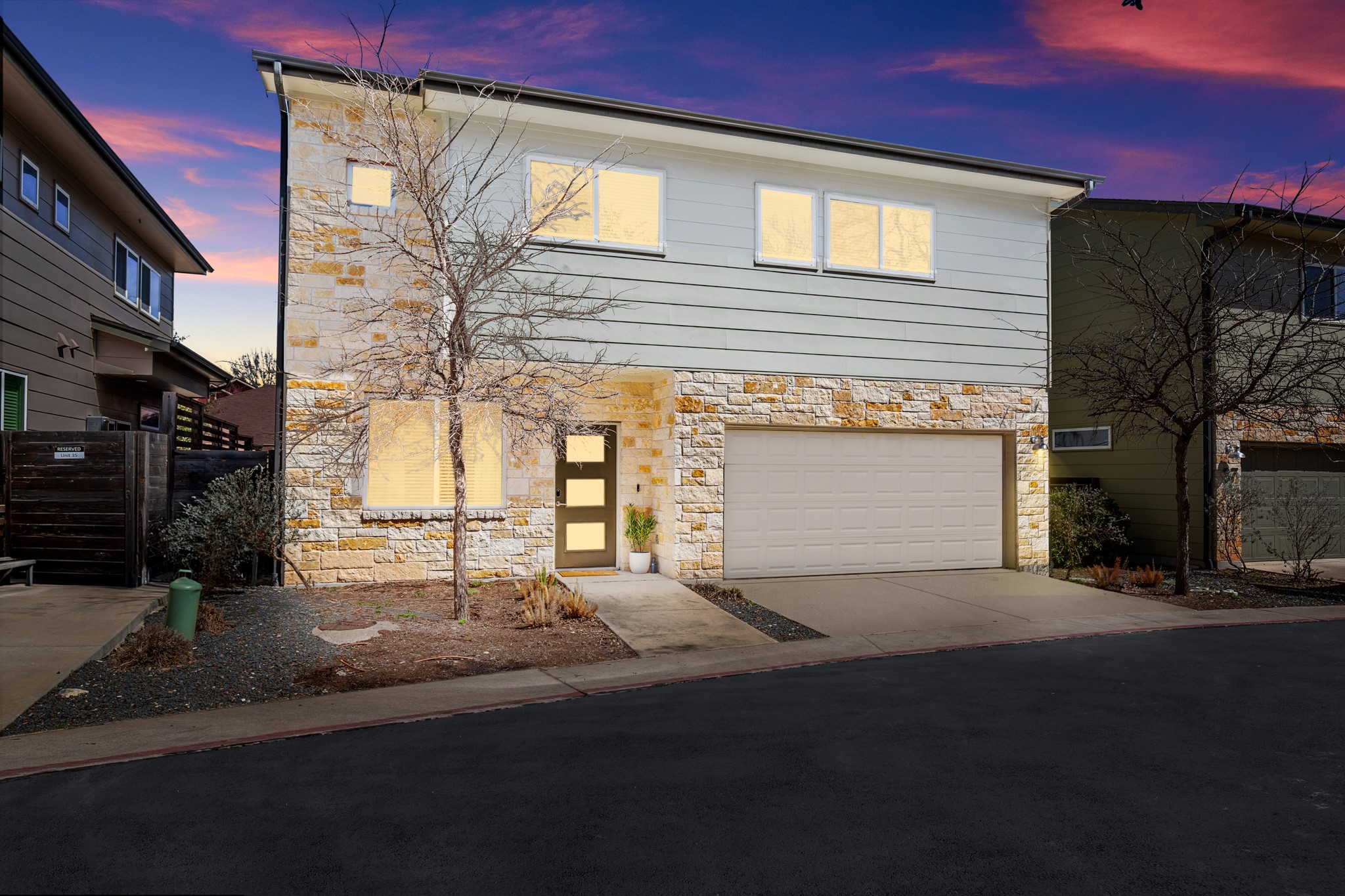 6800 Menchaca Road, Unit 36 Austin, TX 78745 - Photo 1 of 1 View of front of home with a garage, stone siding, and driveway