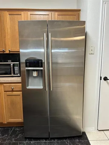 a kitchen with a refrigerator and cabinets
