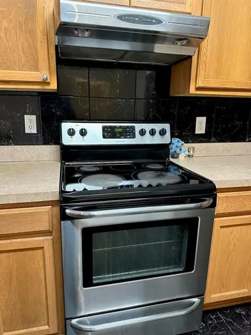 a stove top oven sitting inside of a kitchen