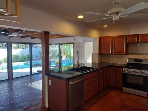 a kitchen with kitchen island granite countertop a stove a sink and a counter top space