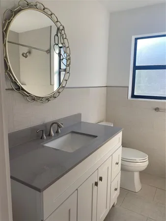 a bathroom with a sink a mirror and toilet