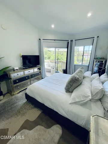 a bedroom with a bed window and a flat screen tv