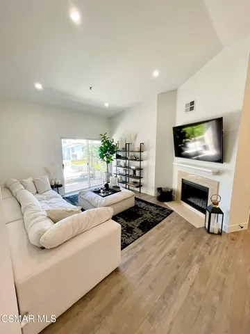 a living room with furniture a fireplace and a flat screen tv