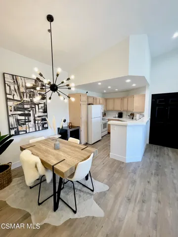 a kitchen with a table chairs appliances and cabinets