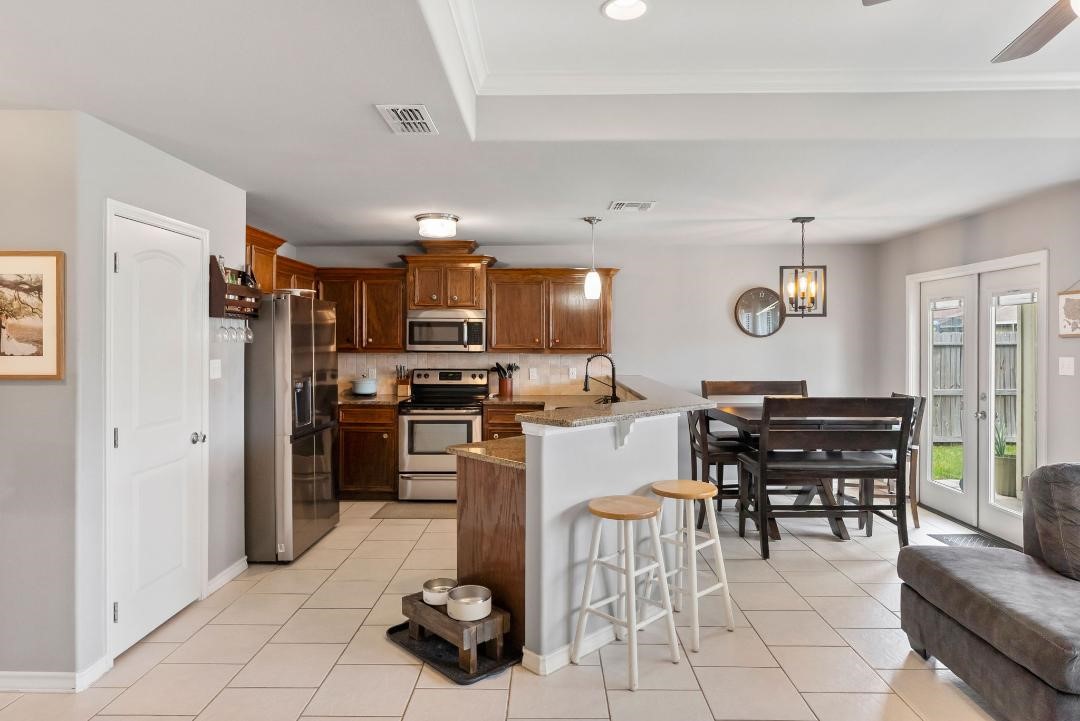 4328 Bratton Road Corpus Christi, TX 78413 - Photo 8 of 24 a kitchen with a refrigerator and a dining table