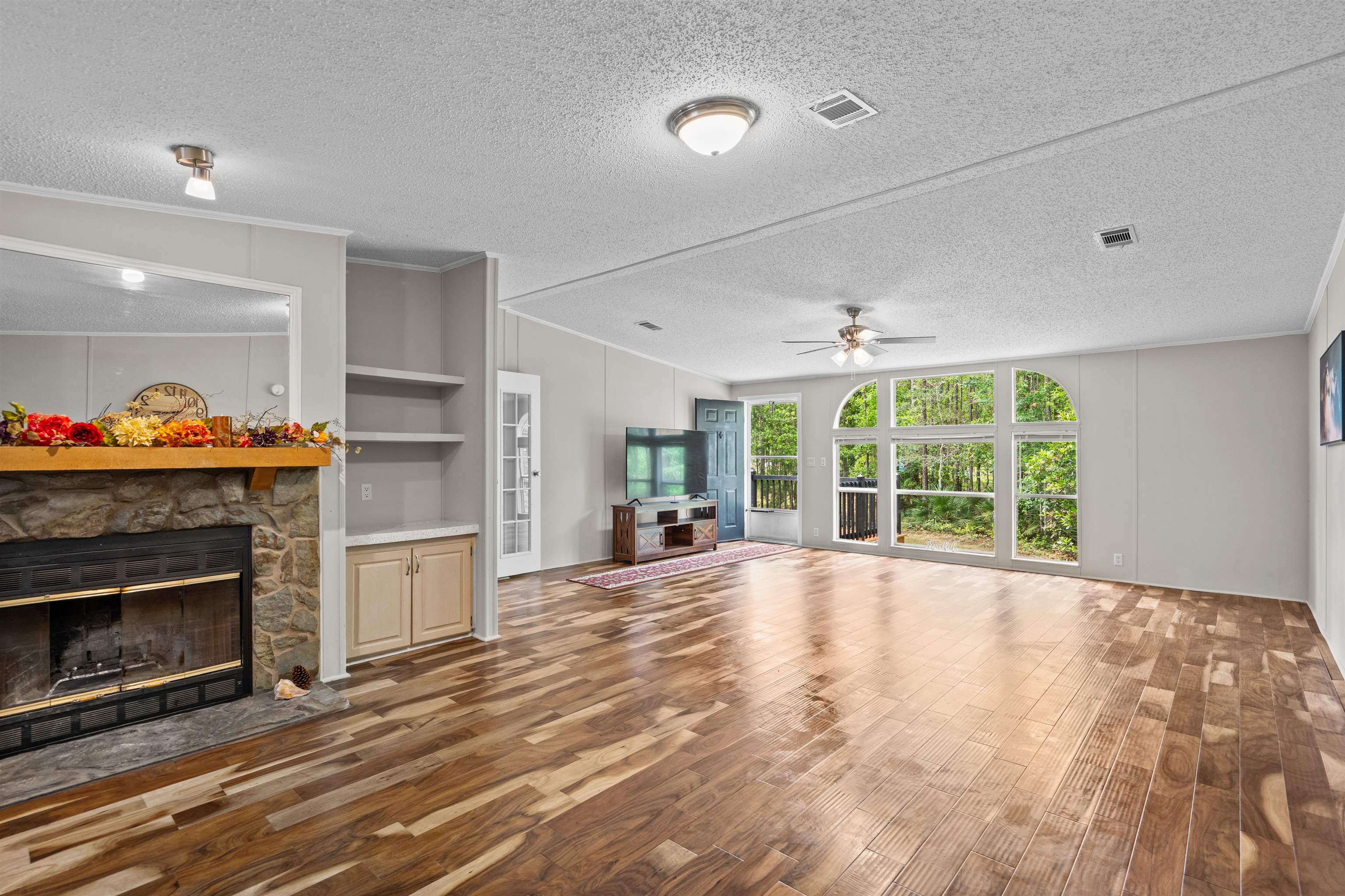 2130 Carter Road St. Augustine, FL 32084 - Photo 11 of 67 Unfurnished living room with dark wood-style floors, a fireplace, built in features, a ceiling fan, and ornamental molding