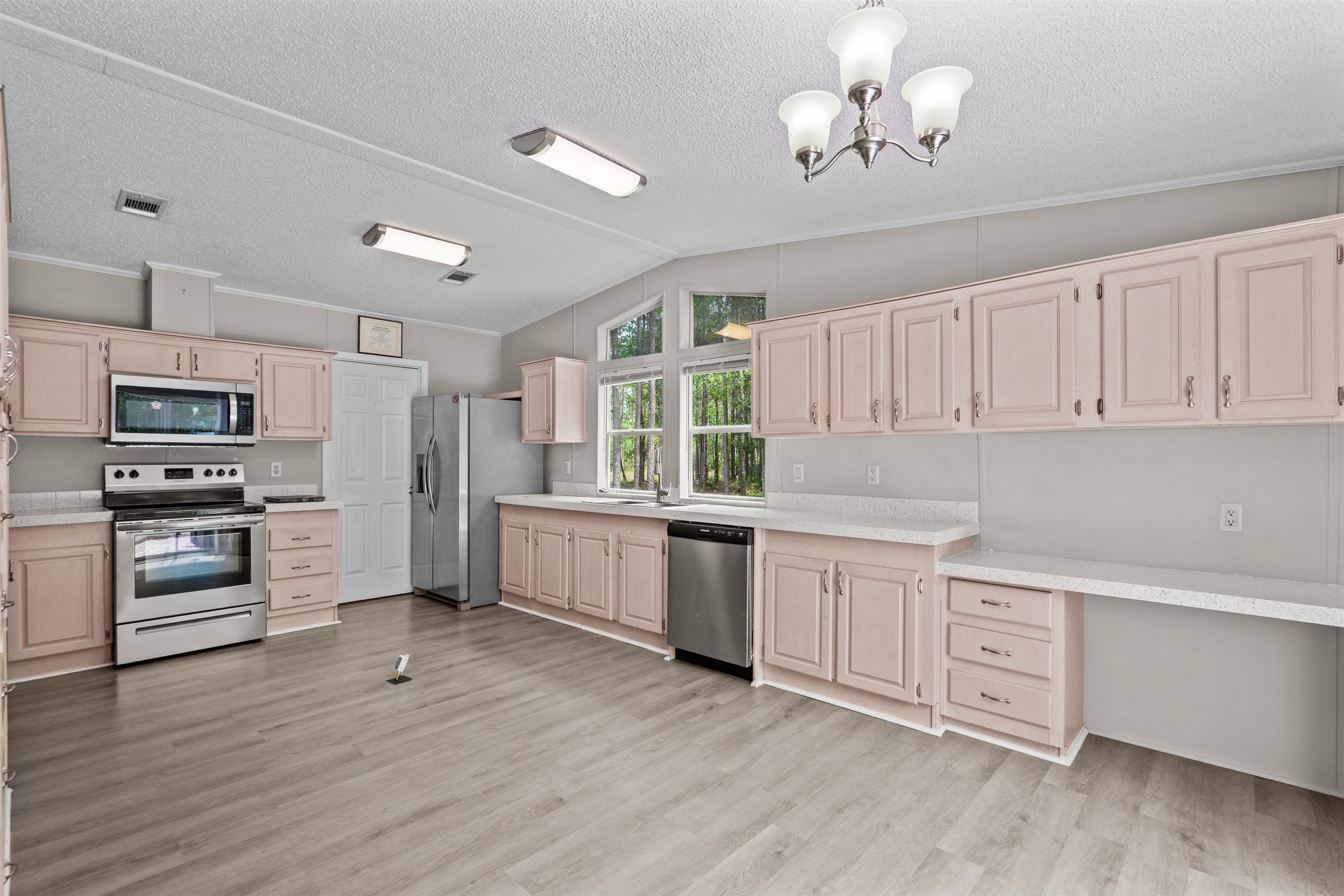 2130 Carter Road St. Augustine, FL 32084 - Photo 14 of 67 Kitchen with stainless steel appliances, light countertops, light wood finish cabinets, light wood-style flooring, and crown molding