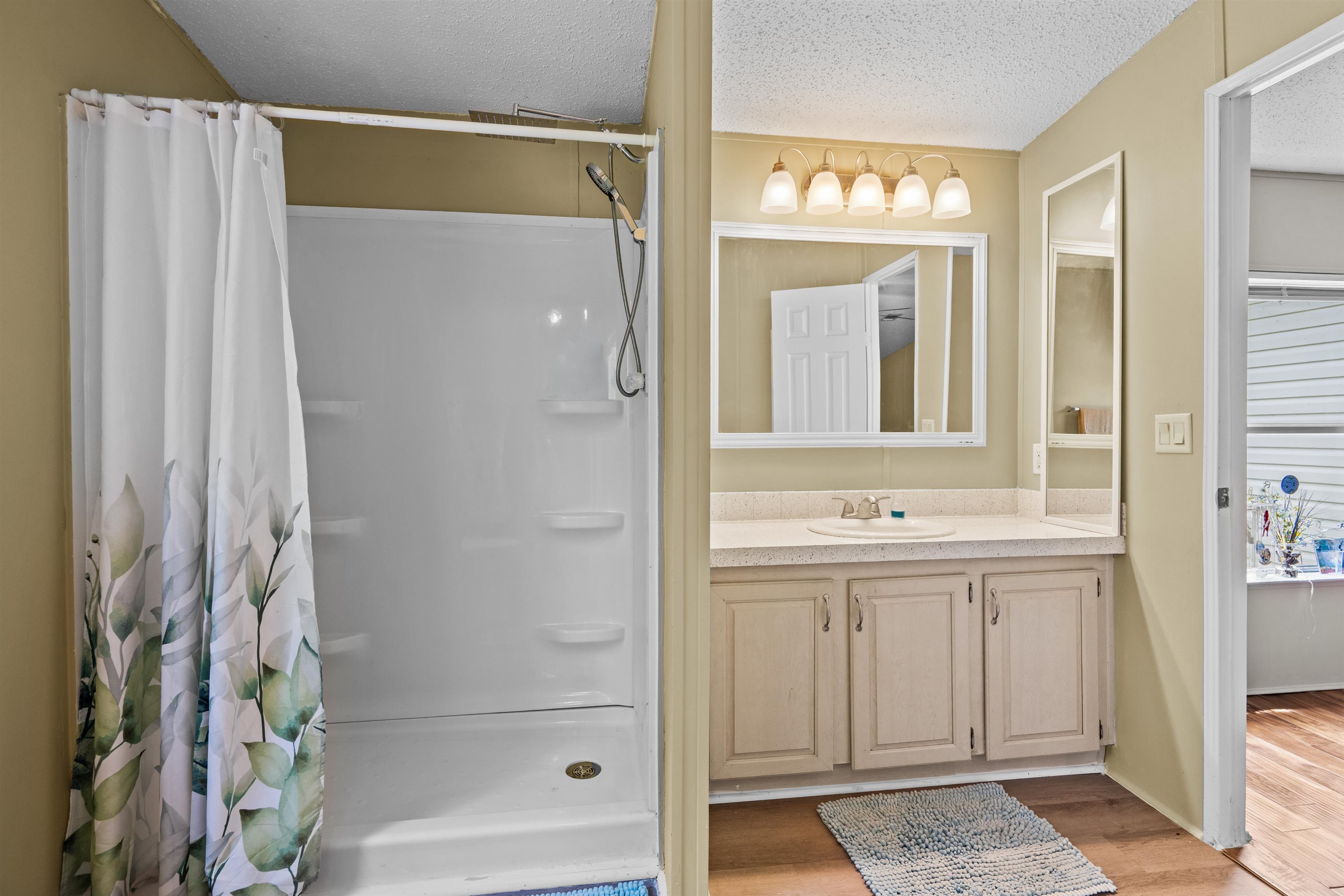 2130 Carter Road St. Augustine, FL 32084 - Photo 23 of 67 Bathroom featuring vanity, a shower stall, a textured ceiling, and light wood-type flooring