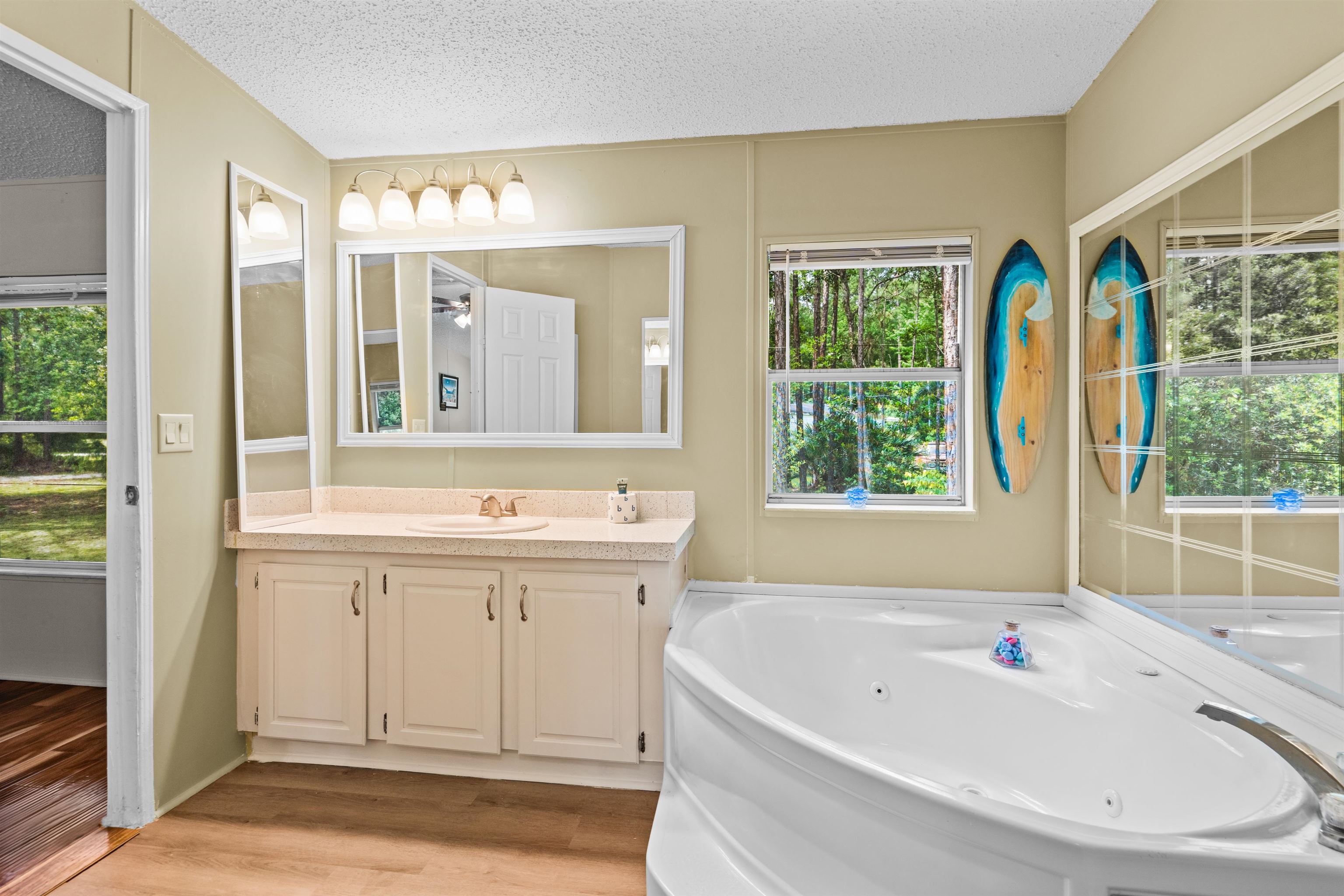 2130 Carter Road St. Augustine, FL 32084 - Photo 26 of 67 Bathroom featuring vanity, a textured ceiling, light wood-type flooring, and a jetted tub