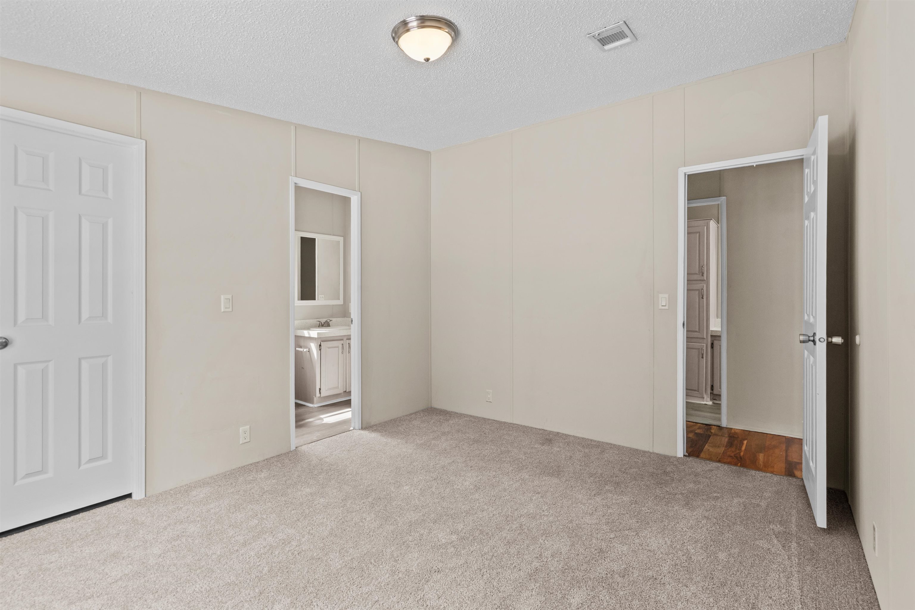 2130 Carter Road St. Augustine, FL 32084 - Photo 29 of 67 Unfurnished bedroom featuring carpet flooring, ensuite bathroom, and a textured ceiling
