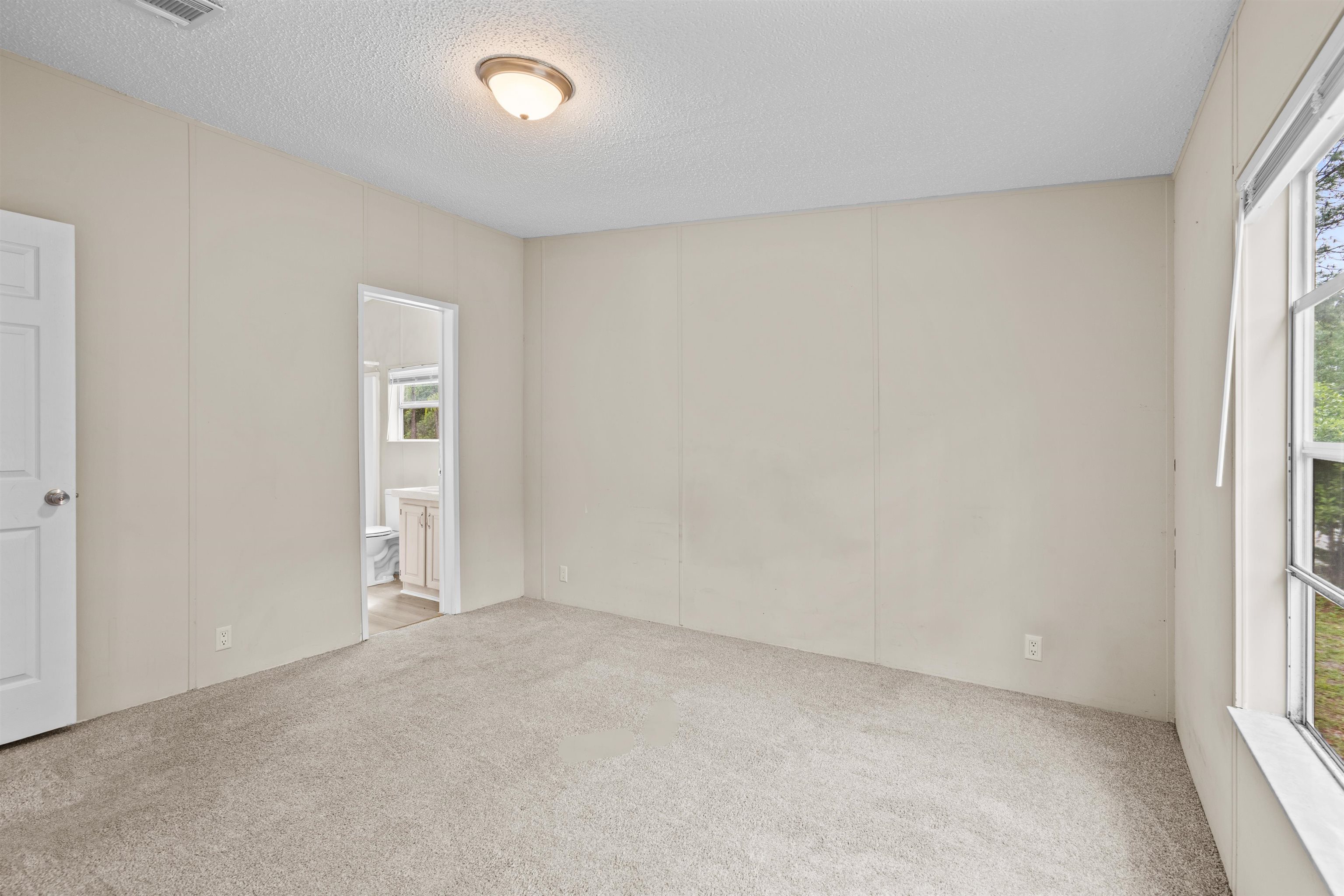2130 Carter Road St. Augustine, FL 32084 - Photo 34 of 67 Unfurnished bedroom with a decorative wall, a textured ceiling, and light colored carpet