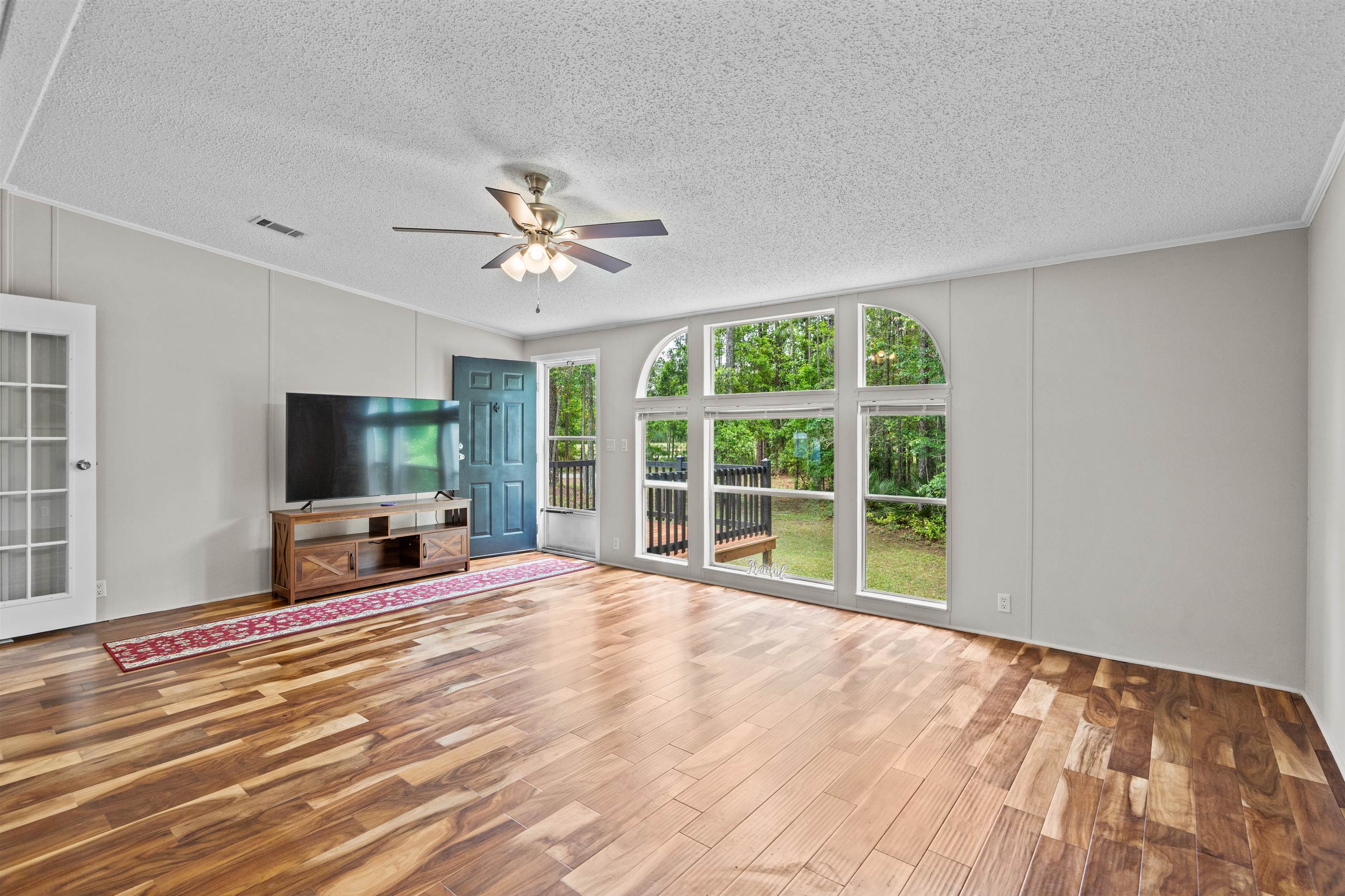 2130 Carter Road St. Augustine, FL 32084 - Photo 9 of 67 Unfurnished living room with a ceiling fan, light wood finished floors, a textured ceiling, and crown molding
