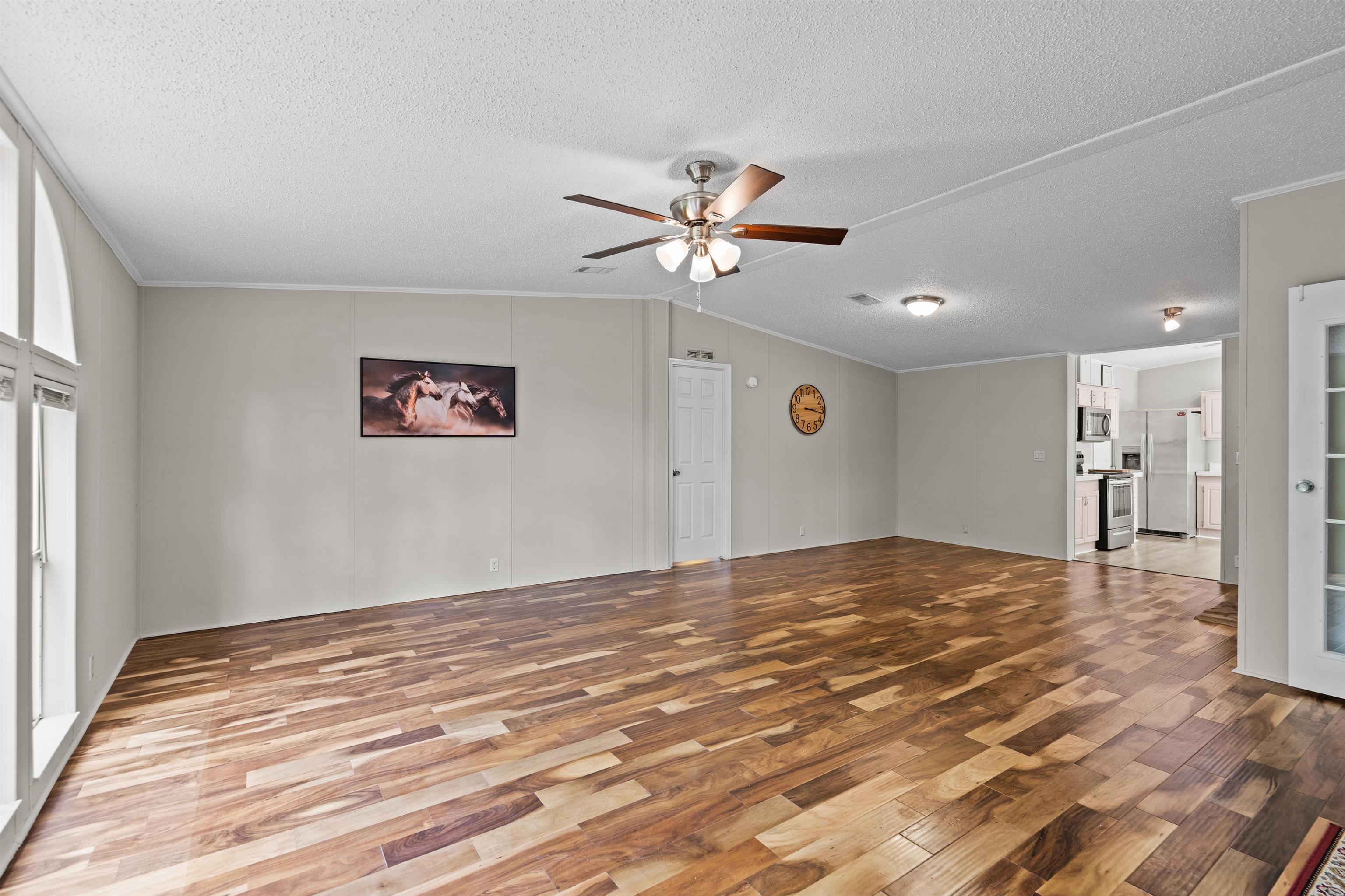 2130 Carter Road St. Augustine, FL 32084 - Photo 10 of 67 Unfurnished living room featuring a ceiling fan, wood finished floors, and crown molding