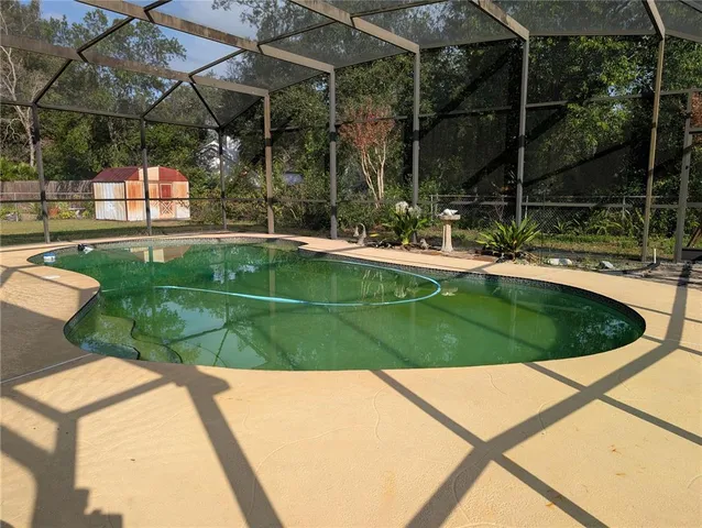 a view of a swimming pool with a patio and a yard