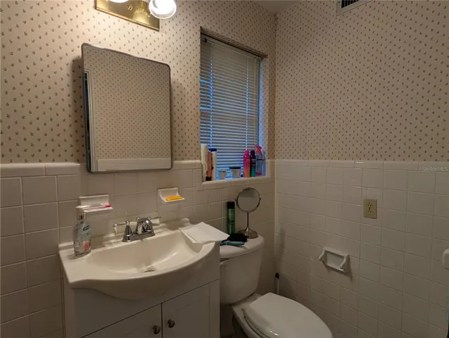 a bathroom with a toilet sink and mirror