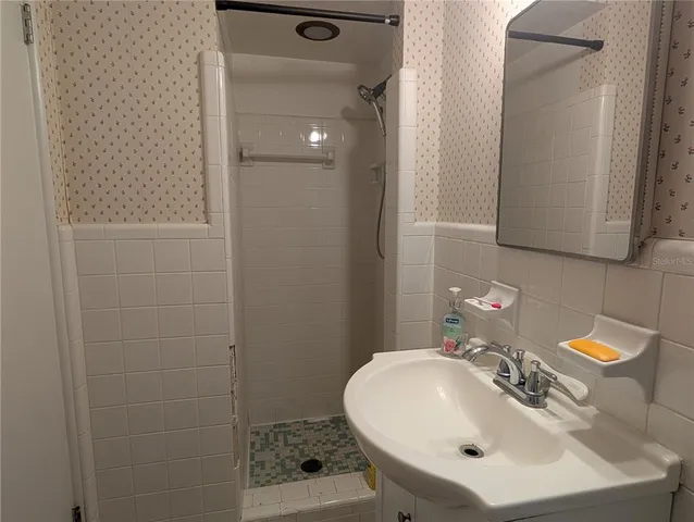 a bathroom with a sink a mirror and shower