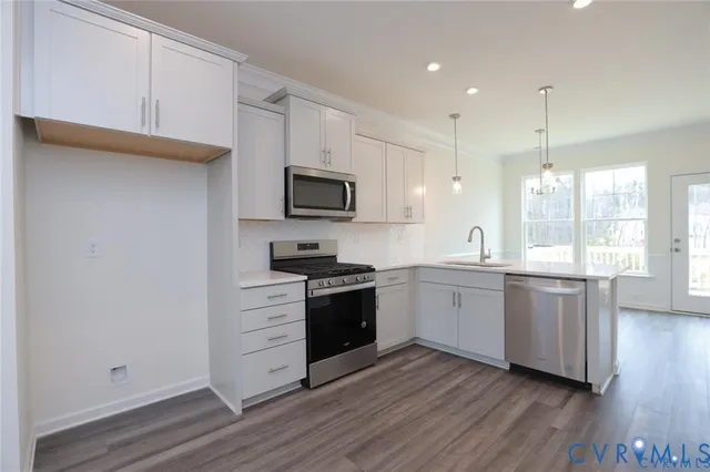 a large kitchen with cabinets wooden floor and stainless steel appliances