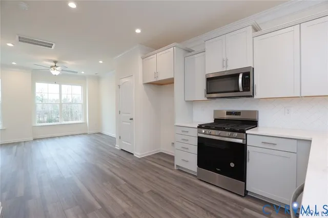 a kitchen with granite countertop wooden floors and stainless steel appliances