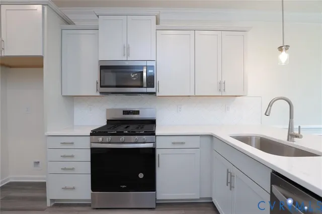 a kitchen with white cabinets and stainless steel appliances