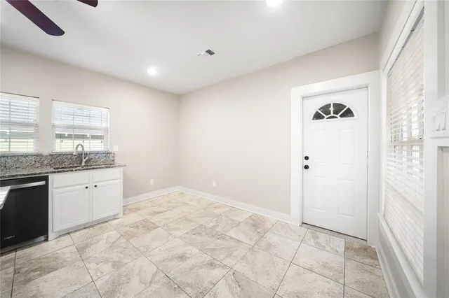 a large white room with a granite countertop sink and a mirror