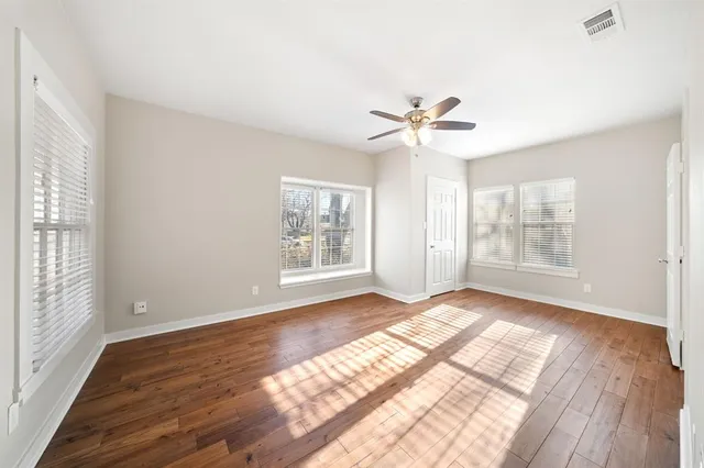 a view of an empty room with a window and a ceiling fan