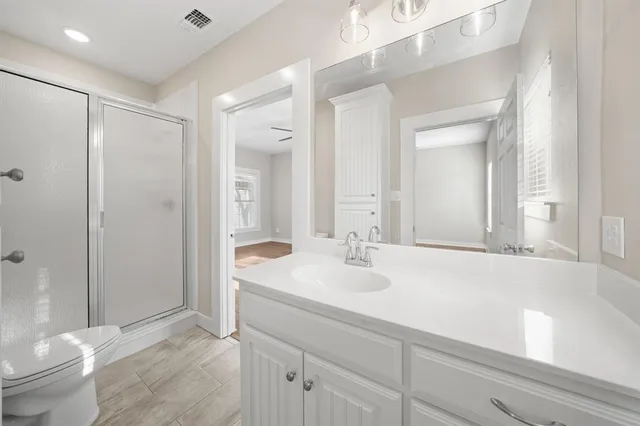 a bathroom with a sink a toilet and shower