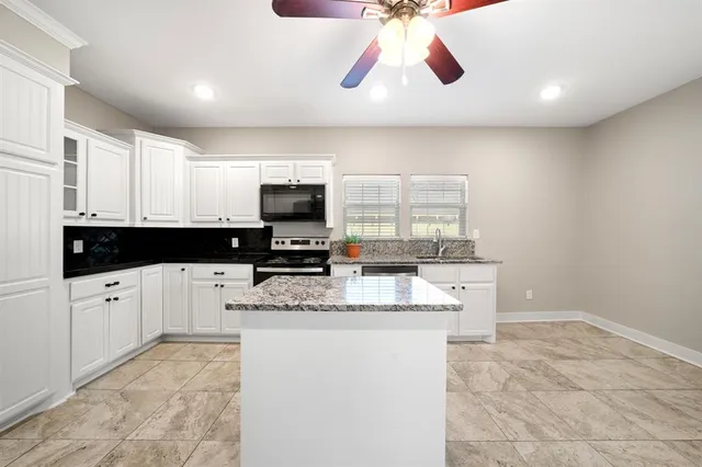 a kitchen with stainless steel appliances granite countertop a sink and a stove top oven