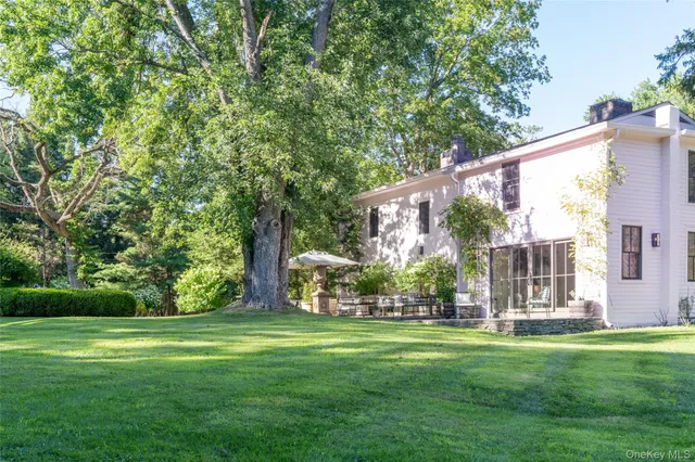 a front view of a house with garden and sitting area