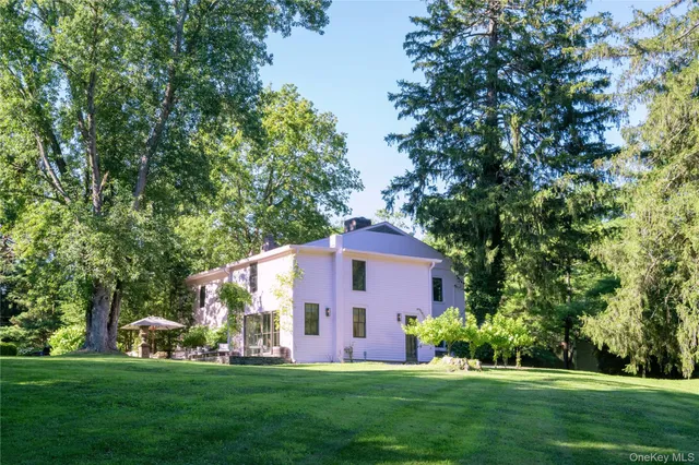a view of a house with a big yard and large trees