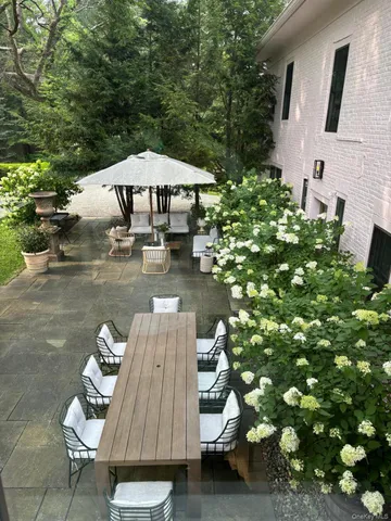 a view of a patio with a table and chairs under an umbrella