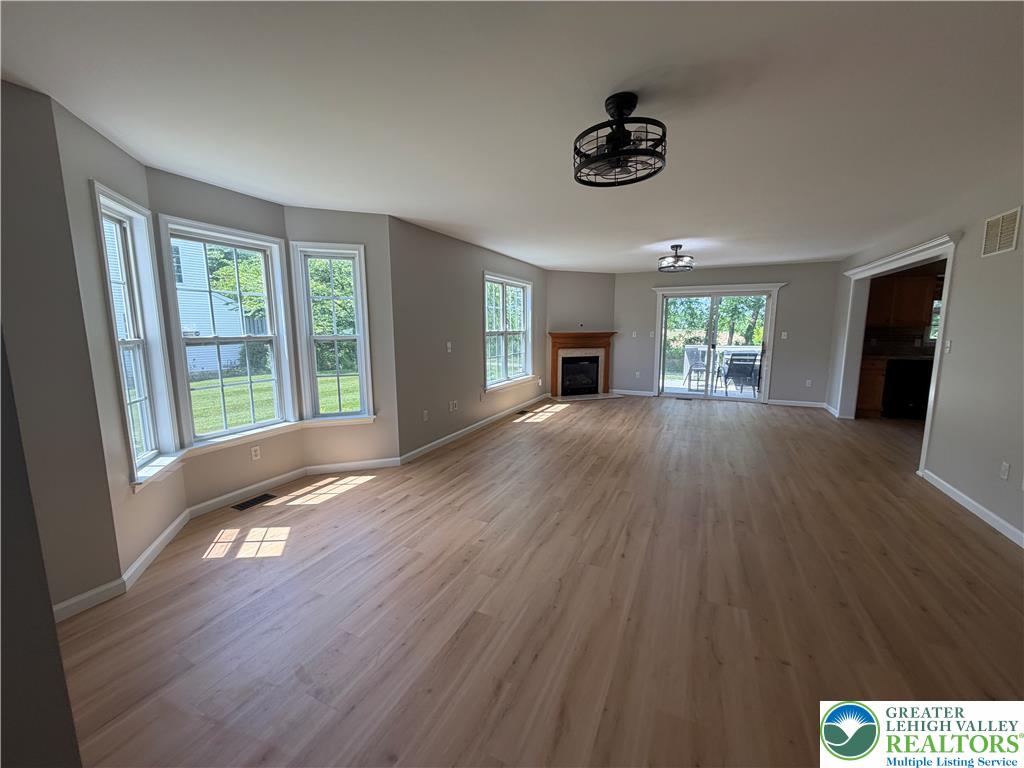 4157 Walter Road Bethlehem, PA 18020 - Photo 9 of 36 Natural light floods this spacious living area featuring durable hardwood floors and a cozy fireplace.