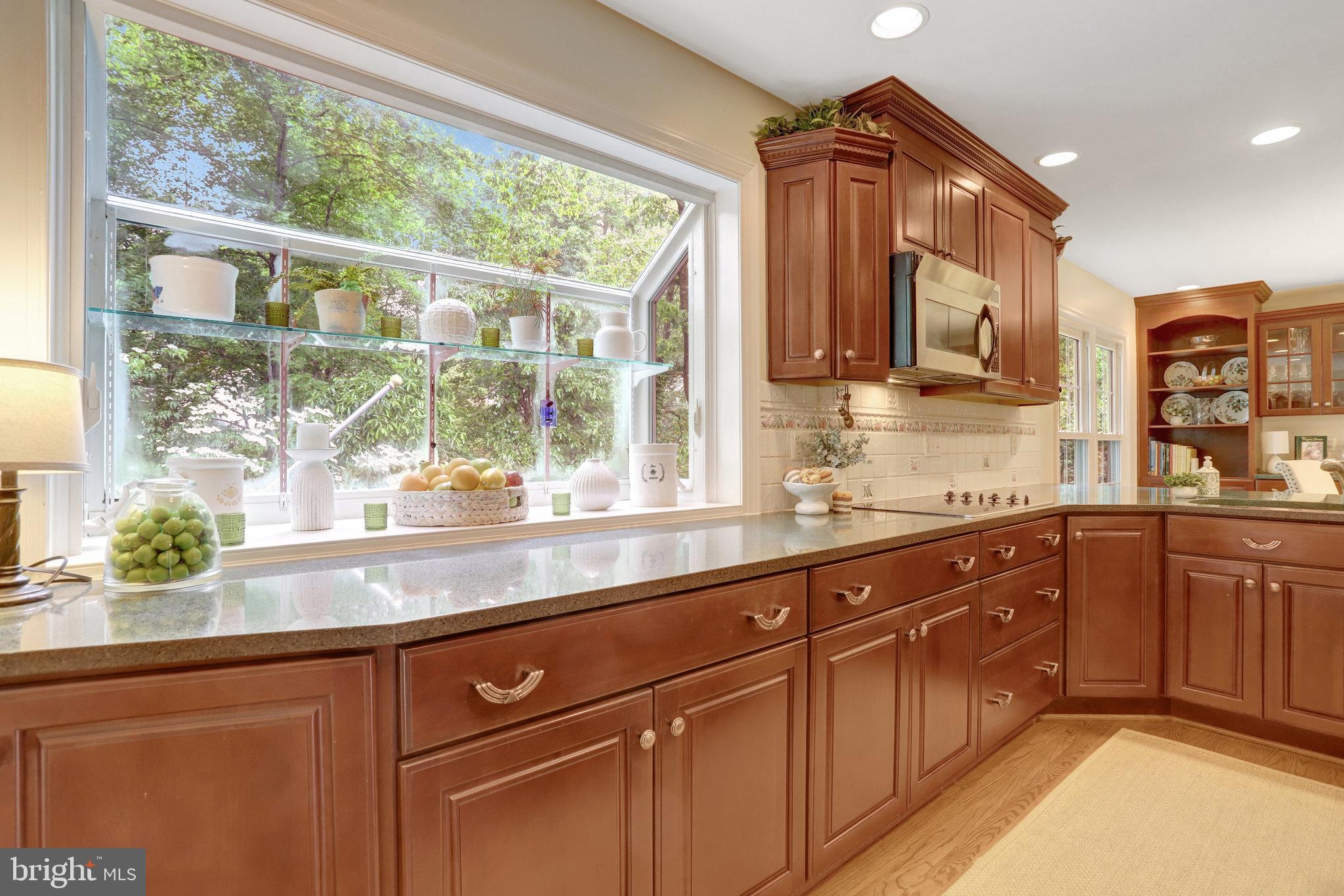 7006 Maple Tree Lane Springfield, VA 22152 - Photo 11 of 49 a kitchen with stainless steel appliances granite countertop a sink and wooden cabinets
