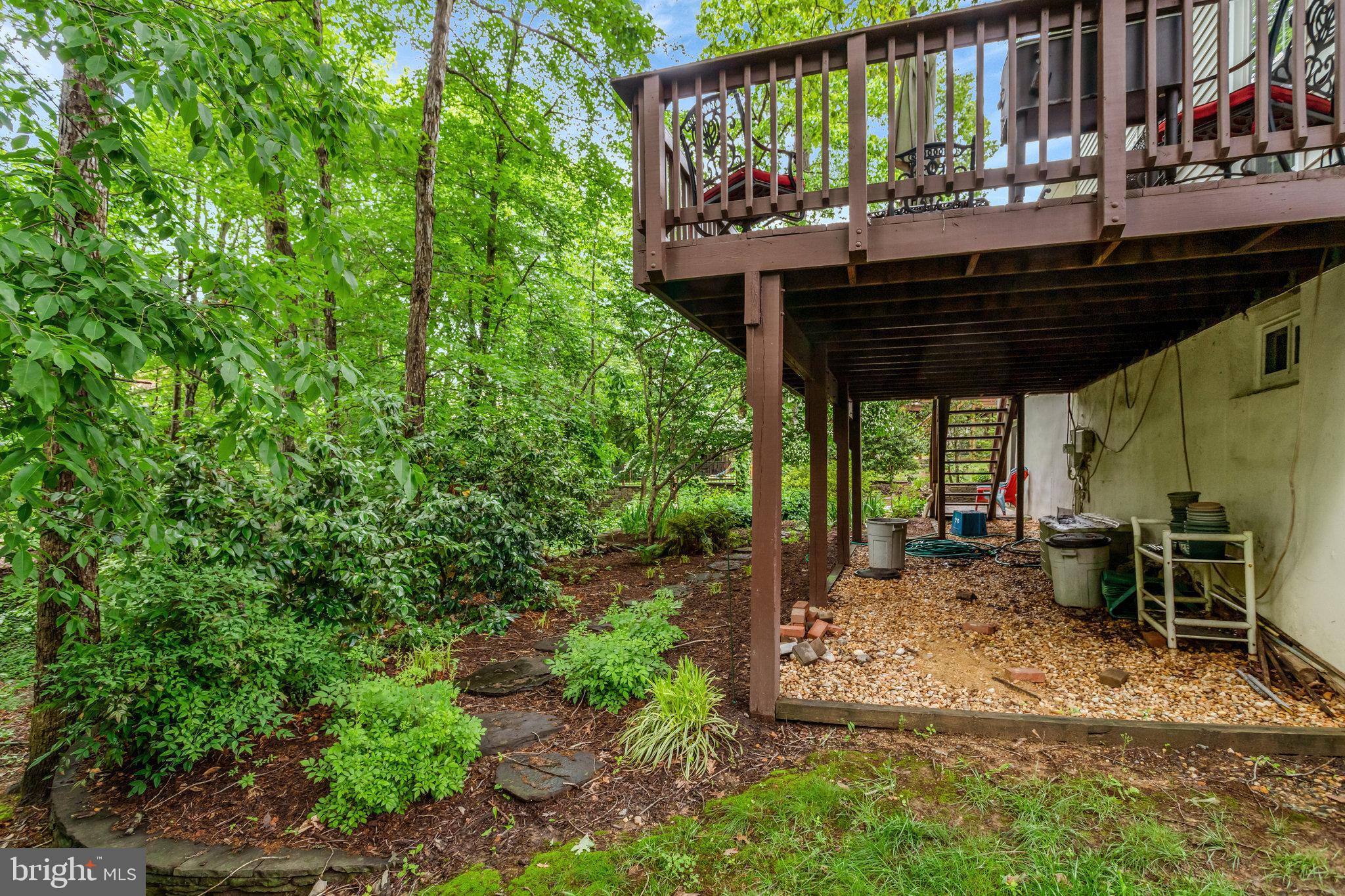 7006 Maple Tree Lane Springfield, VA 22152 - Photo 48 of 49 a view of a patio with table and chairs under an umbrella with a small yard